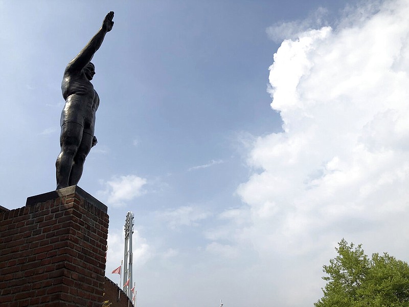 A statue is seen outside Amsterdam's Olympic Stadium on Friday, Aug. 14, 2020. A spokeswoman for the Olympic Stadium says the 10-foot bronze statue of a saluting athlete, which dates to the 1928 Summer Games, will be removed from outside the stadium because its salute is reminiscent of the gesture made infamous at rallies in Nazi Germany.