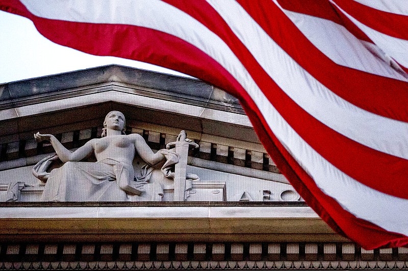 FILE - In this March 22, 2019 file photo, an American flag flies outside the Department of Justice in Washington. 