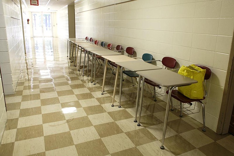 Desks sit in a hallway Thursday at Beryl Henry Elementary School in Hope as staff members rearrange furniture to spread out students. Almost half of Beryl Henry’s students signed up for online learning this fall. The rest will be positioned several feet apart in classrooms in a bid to stop them from spreading the coronavirus. (NWA Democrat-Gazette/Dan Holtmeyer) 