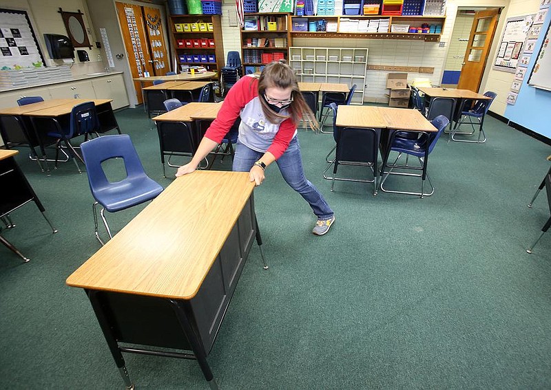 Fifth grade teacher Anna Mask straightens out desks in her classroom that have been socially distanced for students while preparing for the start of school at Williams Magnet Elementary School on Thursday, Aug. 13, 2020, in Little Rock. 
(Arkansas Democrat-Gazette/Thomas Metthe)