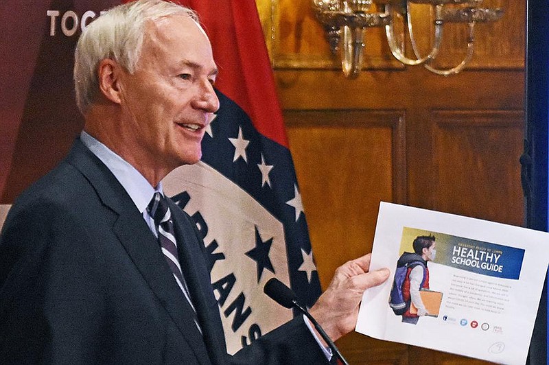 Gov. Asa Hutchinson unveils the Arkansas Ready to Learn Healthy School Guide during Thursday’s briefing at the state Capitol. Hutchinson said the 20-page guide was designed to help “school officials, educators and families plan for in-person learning.”
(Arkansas Democrat-Gazette/Staci Vandagriff)