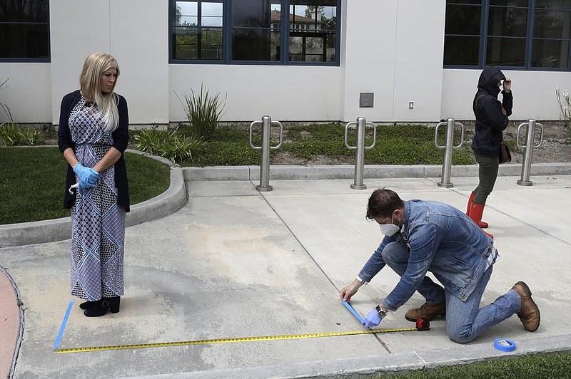 A distance is measured out in April as worshippers line up to take communion on Palm Sunday outside of Godspeak Calvary Chapel in Newbury Park, Calif.
(AP/Marcio Jose Sanchez)