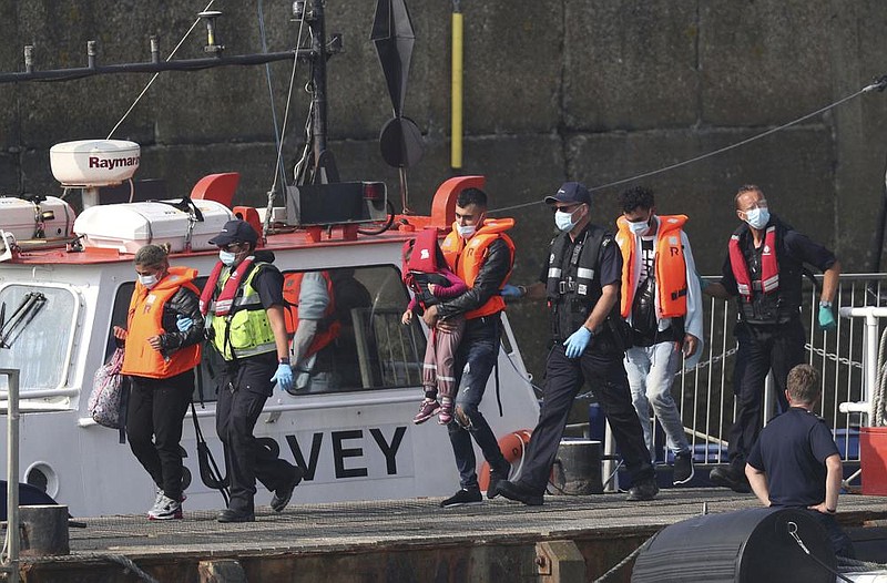 Border Force officials escort people thought to be migrants off a small boat Thursday in Dover, England.
(AP/Steve Parsons)

