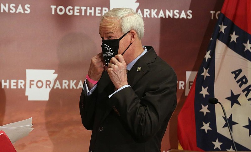 Gov. Asa Hutchinson adjusts his mask after the daily covid-19 press briefing on Friday, Aug. 14, 2020, at the state Capitol in Little Rock. 
(Arkansas Democrat-Gazette/Thomas Metthe)