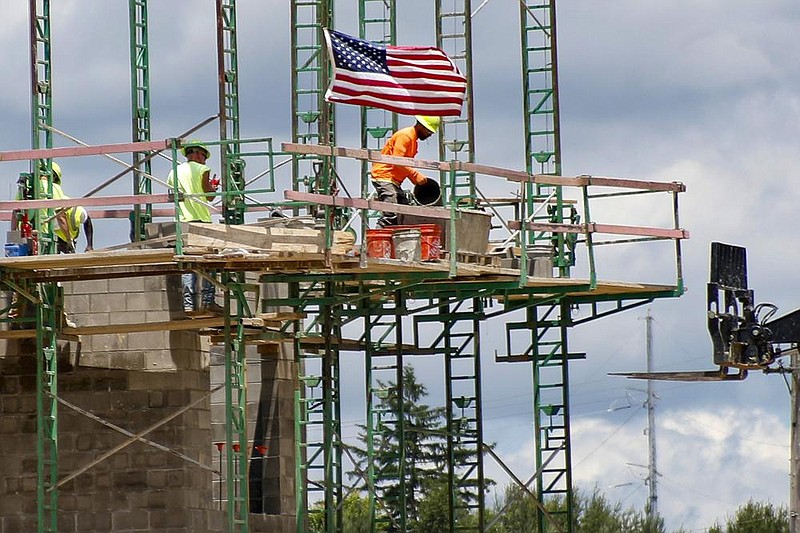 Workers lay concrete blocks at a residential and commercial site going up in June in Cranberry Township, Pa. The government reported Friday that the number of hours worked in the second quarter fell 43% as the pandemic dragged on.
(AP)
