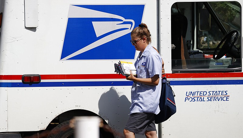A United States Postal Service delivery person goes out on her rounds in Denver in this July 22, 2020, file photo. (AP Photo/David Zalubowski)
