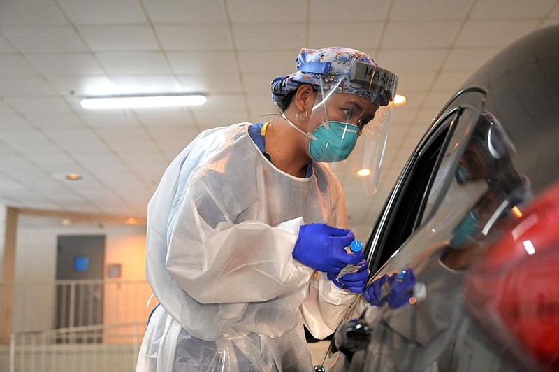 Marcela Cabensag, RN, conducts a test for covid-19 at the UAMS testing center on Tuesday, Aug. 18, 2020. See more photos at arkansasonline.com/819test/. (Arkansas Democrat-Gazette / Stephen Swofford)