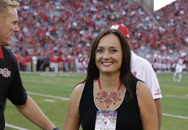 Wendy Anderson, shown walking with her husband onto the eld at Lincoln, Neb., before an Arkansas State game in 2017, died a year ago today after a lengthy battle with breast cancer. “I doubt I’ll ever not think about her,” Blake Anderson said. “I don’t want to ever not think about her because she was my best friend for 27 years.” (AP file photo) 