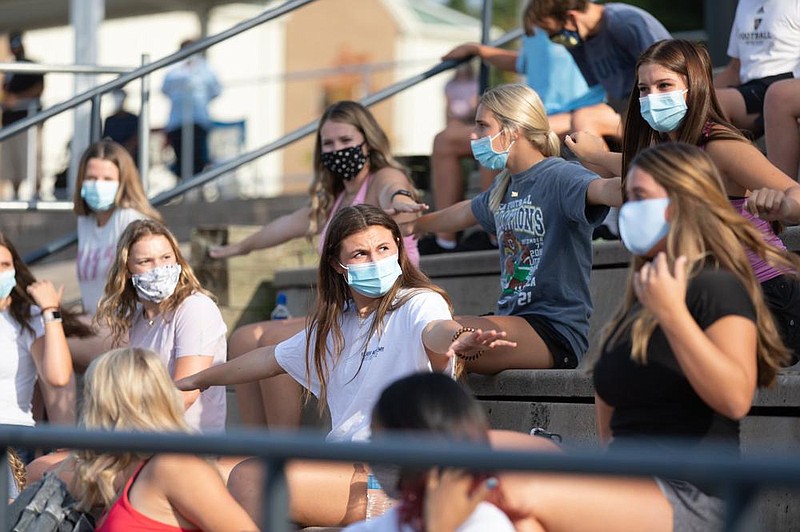 Mask-wearing students practice social distancing by measuring distance between themselves during a high school football scrim- mage at Pulaski Academy in Little Rock on Tuesday. Arkansas Department of Health guidelines for school-sponsored sports include  reducing seating capacity to 66% of a venue’s original capacity.
(Arkansas Democrat-Gazette/Justin Cunningham)