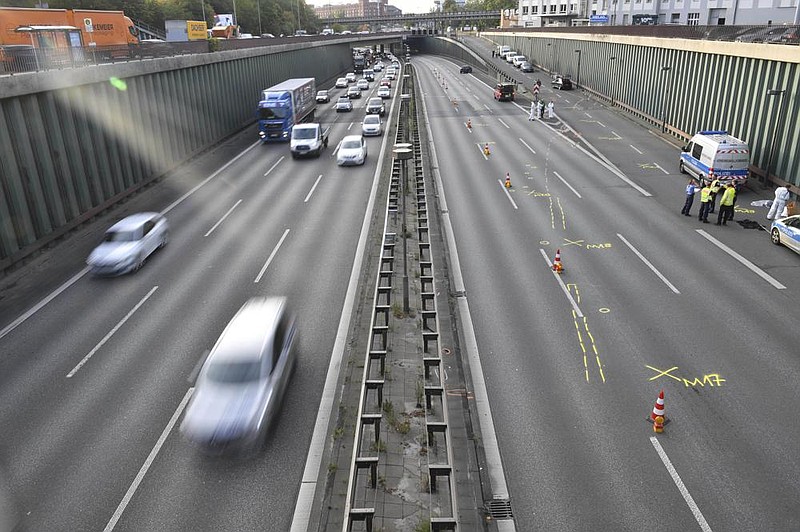 Police officers investigate Wednesday on the Berlin highway where a driver purposely drove into multiple vehicles, authorities say.
(AP/Paul Zinken)