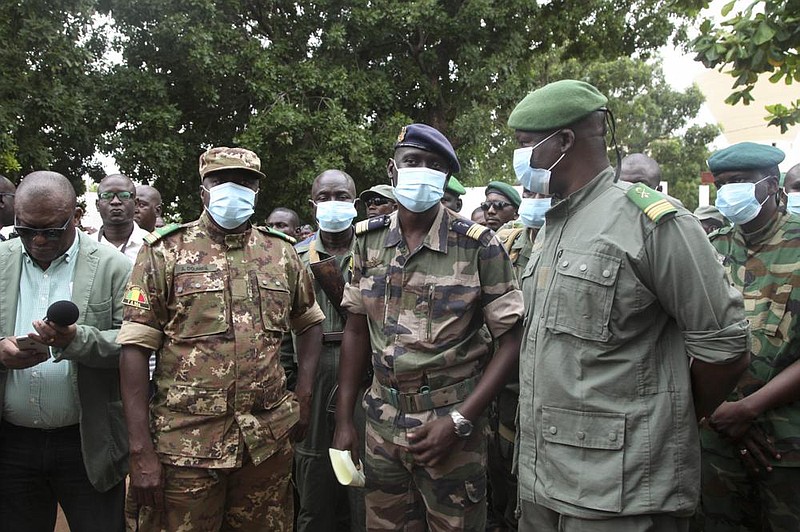 Col.-Maj. Ismael Wague (center), spokesman for the soldiers identifying themselves as the National Committee for the Salvation of the People, said at a news conference Wednesday in Kati, Mali, that “mismanagement, theft and bad governance have become virtues” in his country. More photos at arkansasonline.com/820mali/.
(AP/Baba Ahmed)