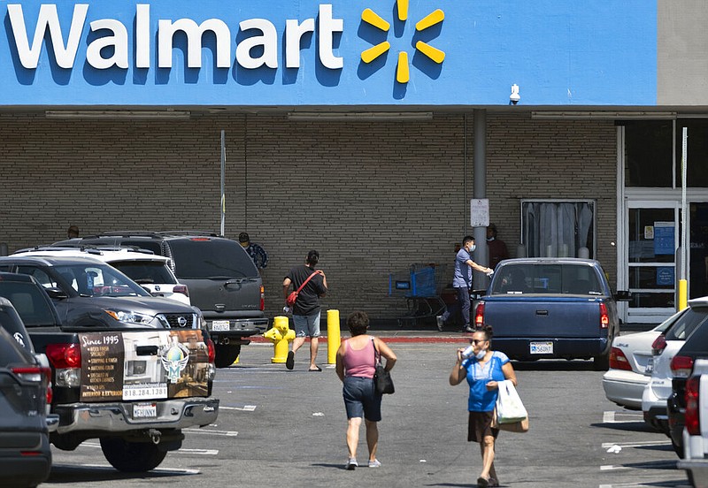 Shoppers walk through the parking lot of a Walmart in the Panorama City section of Los Angeles in this Tuesday, Aug. 3, 2020 file photo. (AP Photo/Richard Vogel)
