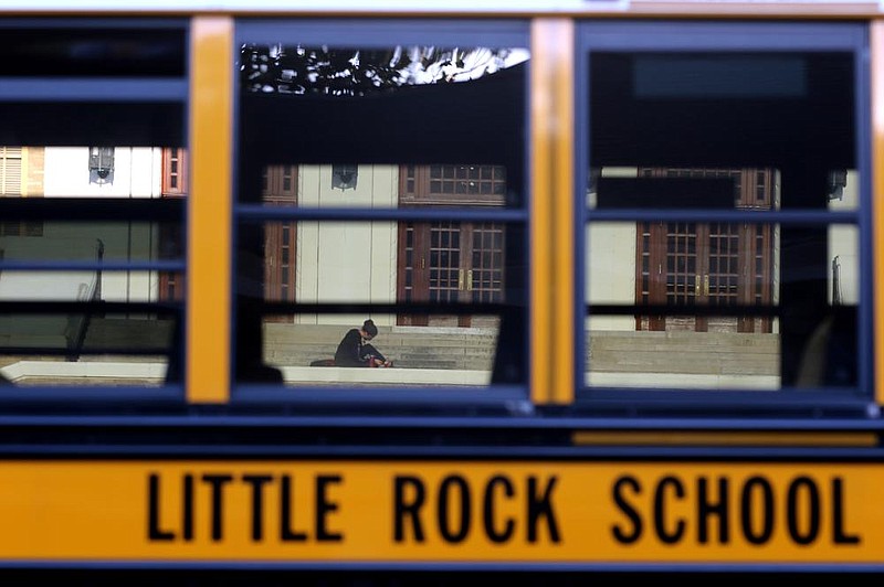 A school bus passes as students head into the building for the first day of school at Little Rock Central High School on Monday, Aug. 24, 2020. 
(Arkansas Democrat-Gazette/Thomas Metthe)