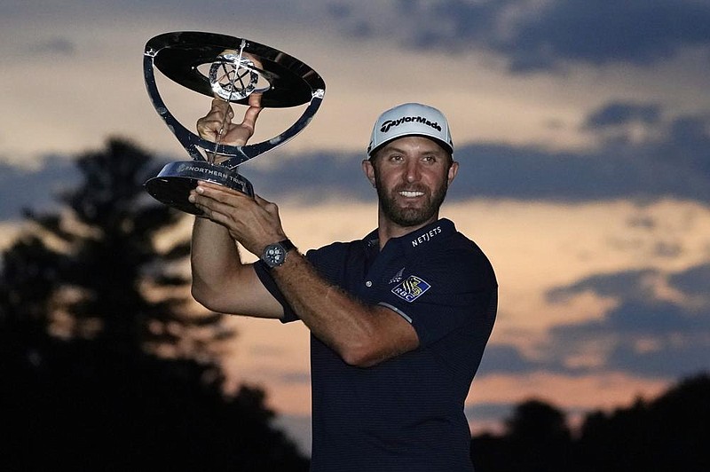 Dustin Johnson holds the trophy after winning the Northern Trust on Sunday at TPC Boston in Norton, Mass. Johnson, who played the final two holes in near darkness after a late storm delay, fired an 8-under 63 and an 11-shot victory over Harris English. More photos at arkansasonline.com/824northern/ 
(AP/Charles Krupa) 
