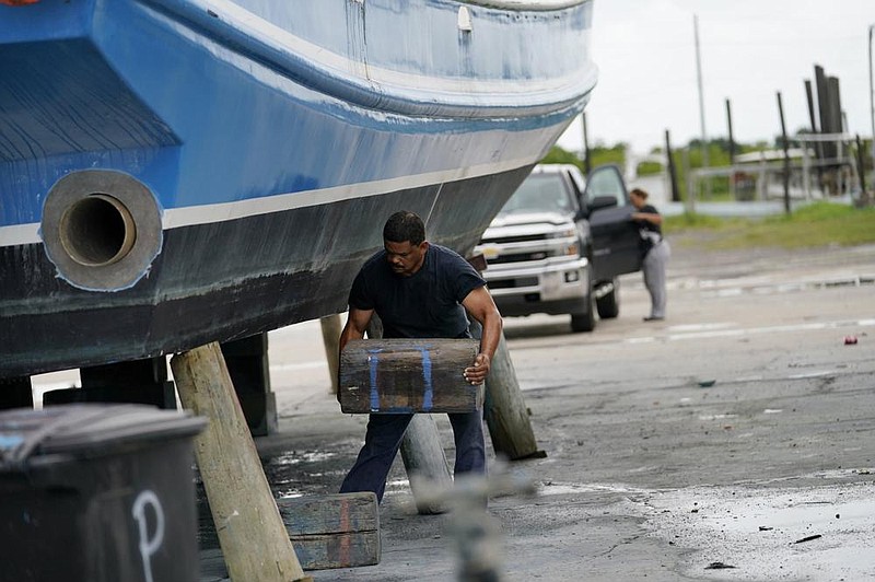 Mike Bartholemey places extra blocks under his shrimp boat Sunday in Empire, La., out of concern for strong winds from the approaching Hurricane Marco. (AP/Gerald Herbert) 
