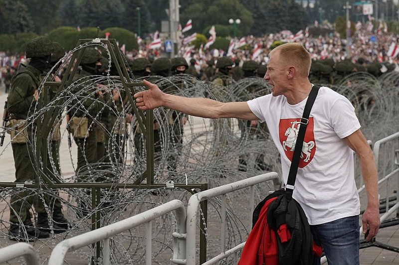 A man tries to speak to riot police who blocked an area against Belarusian opposition members rallying Sunday in Minsk. More photos at arkansasonline.com/824belarus. (AP/Evgeniy Maloletka) 