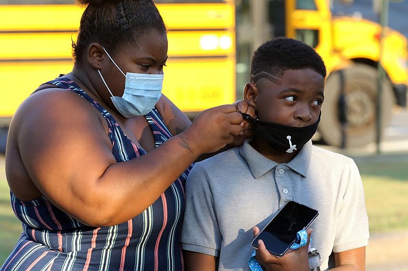 Ariana Jackson adjusts her son, Chayse's, mask before her enters school for his first day of fifth grade on Monday, Aug. 24, 2020, at Stephens Elementary School in Little Rock. 
See more photos at www.arkansasonline.com/825school/
(Arkansas Democrat-Gazette/Thomas Metthe)