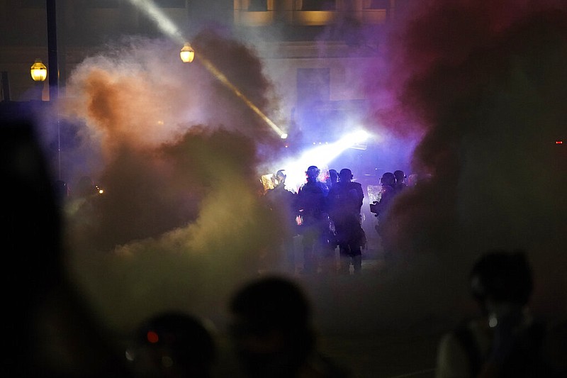 Police in riot gear clear the area in front of Kenosha County Courthouse during clashes with protesters late Tuesday, Aug. 25, 2020, in Kenosha, Wis.