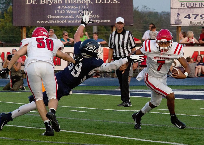  Fort Smith Northside quarterback Dreyden Norwood escapes Greenwood defender Jordan Hanna in the first quarter of Fridayâ€™s game in Greenwood. Blocking on the play is Jacob Arnold.