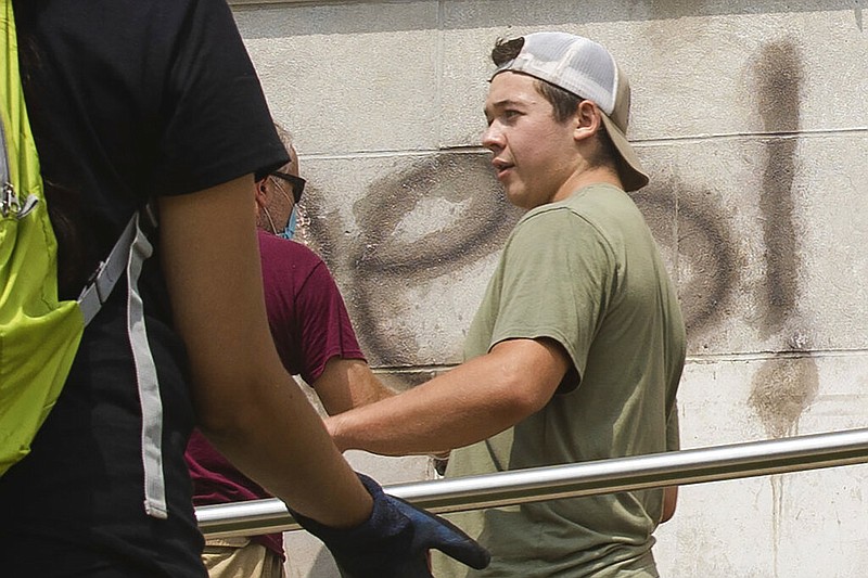 Kyle Rittenhouse helps clean the exterior of Reuther Central High School in Kenosha, Wis., on Tuesday, Aug. 25, 2020. Rittenhouse, 17, was arrested Wednesday, Aug. 26, after two people were shot to death during protests in Kenosha over the police shooting of Jacob Blake.