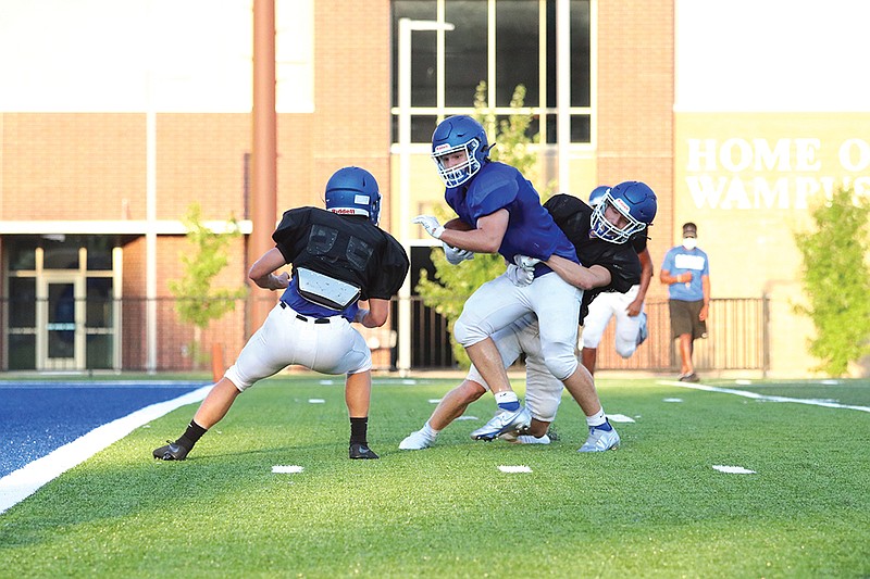 Conway junior tight end Will Vint is tackled by junior Trey Roberts during a recent scrimmage. Last year, the Wampus Cats finished 8-4, following a quarterfinal loss at Bentonville West in the state playoffs.
