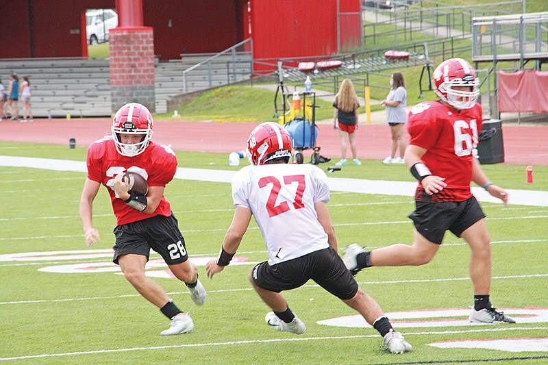 Cabot junior Ethan Roberts, left, avoids being tackled by senior Bryant Hiddle at a practice on Aug. 27. Head coach Scott Reed said he “really likes the work ethic of our team.”
