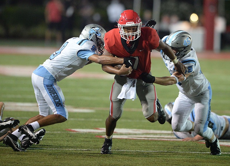 Fort Smith Northside quarterback Dreyden Norwood (center) carries the ball Thursday, Aug. 27, 2020, as Fort Smith Southside defenders Davon Solomon (left) and Bailey Proctor reach to bring him down during the first half of play at Mayo-Thompson Stadium in Fort Smith. (NWA Democrat-Gazette/Andy Shupe)