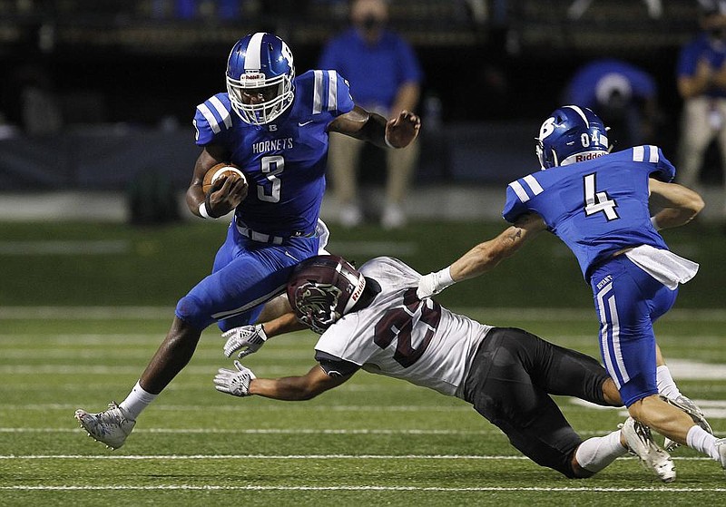 Bryant running back Jamarien Bracey (3) hurdles Benton defensive back Cain Simmons (22) during the second quarter of the Salt Bowl on Saturday at War Memorial Stadium in Little Rock. Bryant won 48-7. See more photos at arkansasonline.com/830salt/
(Arkansas Democrat-Gazette/Thomas Metthe)