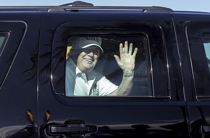 President Donald Trump waves to supporters from his motorcade on Dec. 28, 2017, en route to his Mar-a-Lago estate from Trump International Golf Club in West Palm Beach, Fla. (AP file photo) 
