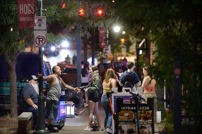 People speak on the sidewalk Friday, Aug. 28, 2020, as a line forms outside bars on Dickson Street in Fayetteville. Visit nwaonline.com/200906Daily/ for today's photo gallery.
(NWA Democrat-Gazette/Andy Shupe)