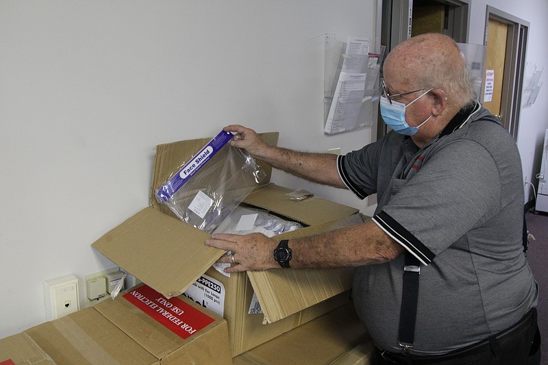 Jefferson County Election Commission Chairman Michael Adam inspects a case of personal protective equipment sent to the commission to be used in the upcoming Nov. 3 General Election. In recent days, the commission has established polling sites for the election and assigned ballot positions to all candidates who will appear on any Jefferson County ballot. (The Pine Bluff Commercial/Dale Ellis)