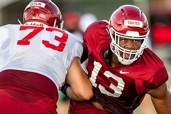 Arkansas defensive end Julius Coates (13) goes against offensive lineman Noah Gatlin (73) during practice Monday, Aug. 24, 2020, in Fayetteville.