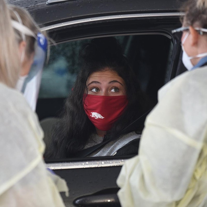 Karson Freeman, a University of Arkansas, Fayetteville freshman from Little Rock, prepares to undergo coronavirus testing Tuesday at a drive-thru clinic across from Baum-Walker Stadium on the outskirts of the UA campus. Health Department officials said that 350 people were tested at the site Tuesday after the campus reported a surge in cases last week and over the weekend. 
(NWA Democrat-Gazette/David Gottschalk) 