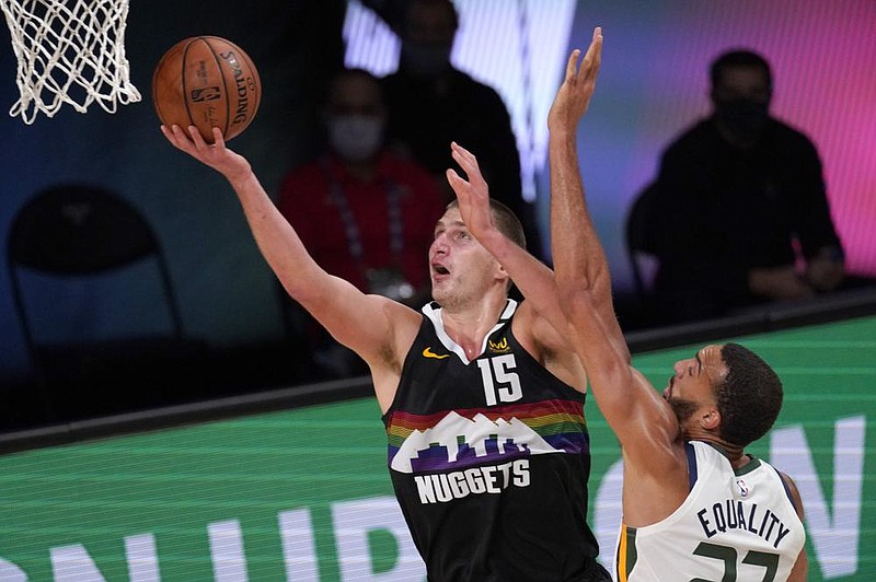 Denver’s Nikola Jokic (15) goes up for a shot in front of Utah’s Rudy Gobert on Tuesday during the Nuggets’ 80-78 victory over the Jazz in Lake Buena Vista, Fla. (AP/Mark J. Terrill) 