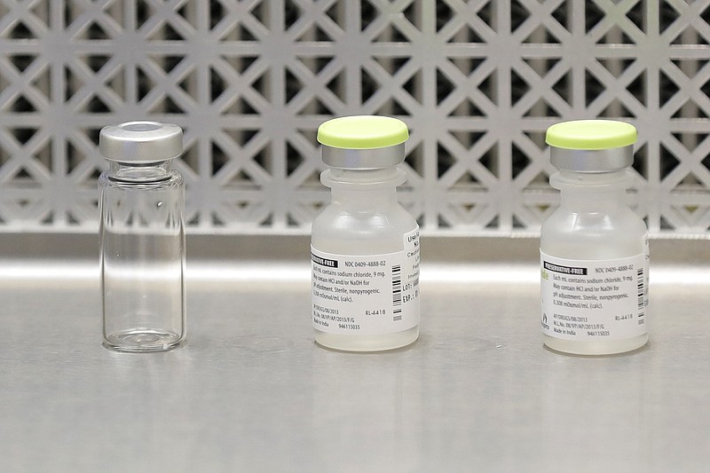 This March 16, 2020 file photo shows vials used by pharmacists to prepare syringes used on the first day of a first-stage safety study clinical trial of the potential vaccine for COVID-19, the disease caused by the new coronavirus, in Seattle. As the nation awaits a vaccine to end the pandemic, local health departments say they lack the staff, money and tools to distribute, administer and track millions of vaccines, most of which will require two doses.
