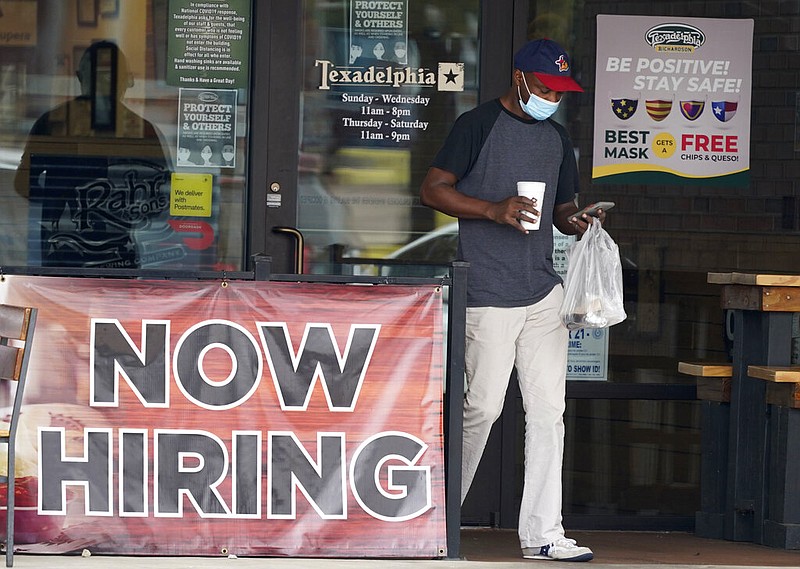 FILE - In this Sept. 2, 2020, file photo, a customer walks past a now hiring sign at an eatery in Richardson, Texas. The Labor Department reported unemployment numbers Thursday, Sept. 3.