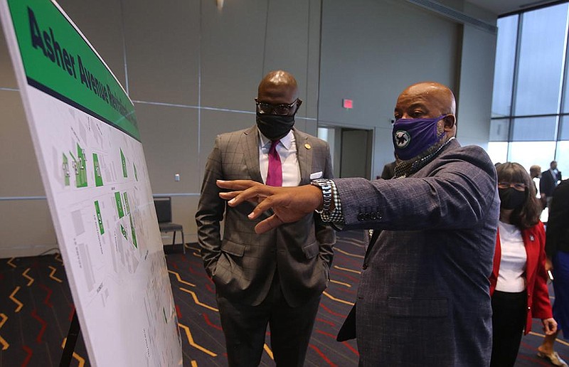 Little Rock Mayor Frank Scott Jr. (left) looks over a map with business owner Tracy Johnson after a news conference Wednesday on the revitalization plan for the Asher Avenue corridor. The exact areas that will be eligible for incentives were still being finalized, and a map will be available next week, officials said.
(Arkansas Democrat-Gazette/Thomas Metthe)