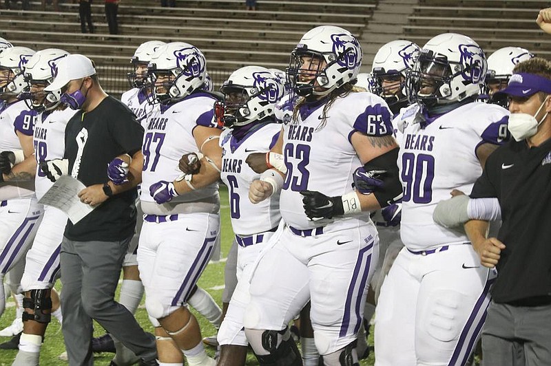 Central Arkansas Coach Nathan Brown (left) walks onto the field with his players before the Bears’ victory over Austin Peay on Saturday night. The school said Wednesday there have been no positive covid-19 tests on the team after two rounds of testing after the game.
(Photo courtesy of University of Central Arkansas)