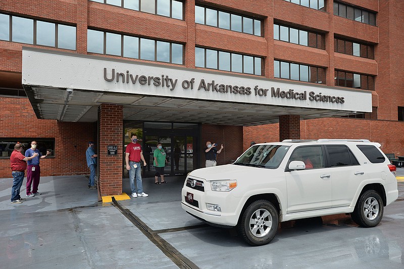 A vehicle drives Friday, May 22, 2020, past the University of Arkansas for Medical Sciences Northwest entrance to honor healthcare workers during the Horns for Heroes event at the medical center campus in Fayetteville. (NWA Democrat-Gazette/Andy Shupe)