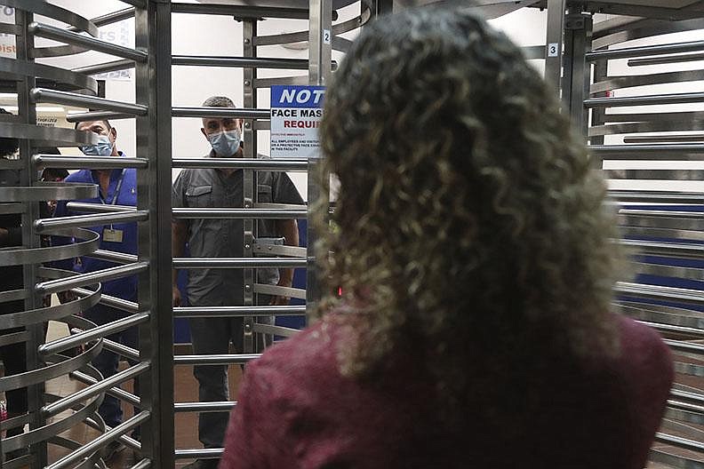 Postal workers talk with U.S. Rep. Debbie Wasserman Schultz, D-Fla., through metal turnstiles Friday at the blocked entrance to the Miami Processing and Distribution Center in Miami.
(AP/South Florida Sun-Sentinel/Amy Beth Bennett)