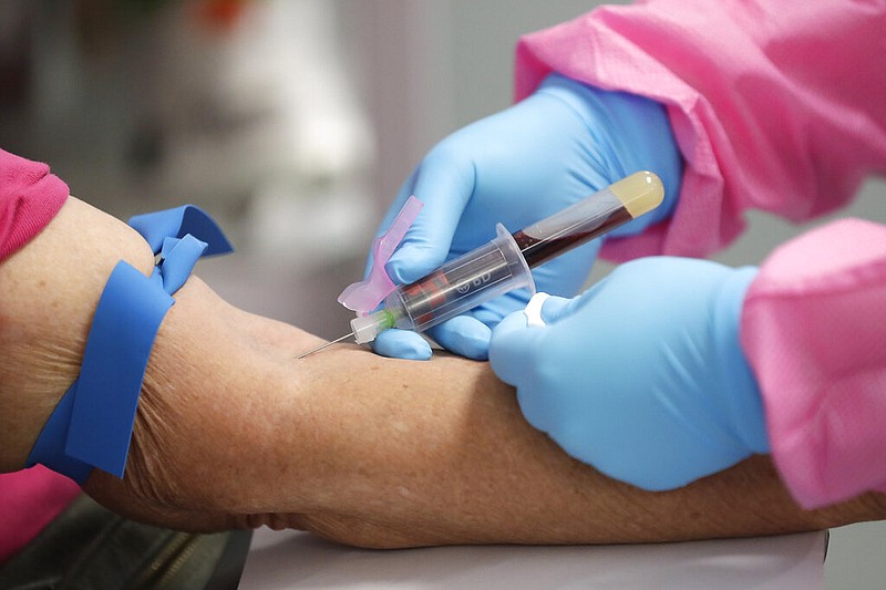 FILE - In this Tuesday, May 5, 2020 file photo, a health worker draws blood from a patient for a COVID-19 coronavirus antibody test in DeLand, Fla. Scientists are still working to figure out how well antibodies for the new coronavirus may shield someone from another infection, or how long that protection might last. (AP Photo/John Raoux)