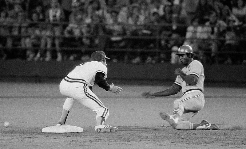 Lou Brock of the St. Louis Cardinals slides into second base as the ball eludes San Diego shortstop Bill Almon on Aug. 29, 1977, in San Diego. Brock set the major league record for stolen bases with the steal. Brock’s record would later be broken by Rickey Henderson. (AP file photo) 