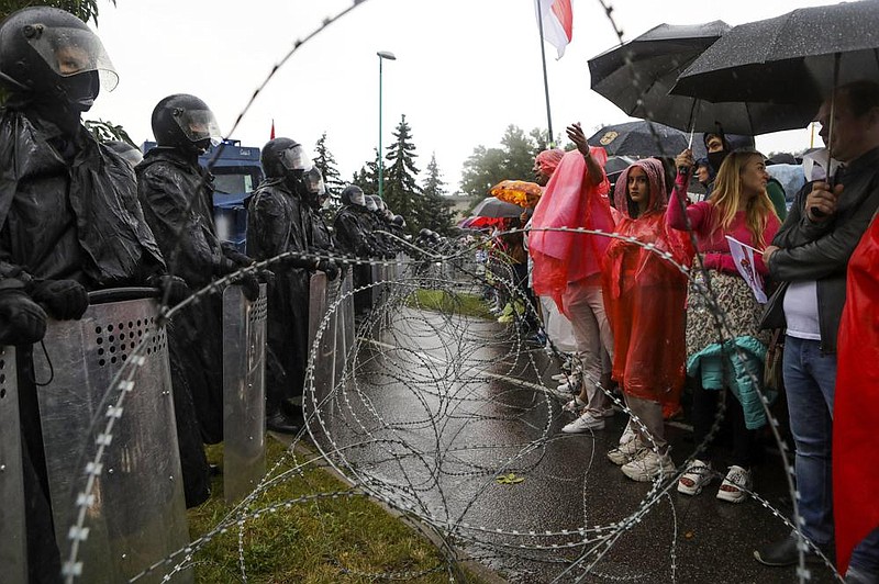 Protesters in Minsk, Belarus, confront police Sunday at a bar- ricade that blocks off Independence Palace, the residence of President Alexander Lukashenko. More photos at arkansasonline. com/97belarus/.
(AP) story.lead_photo.caption