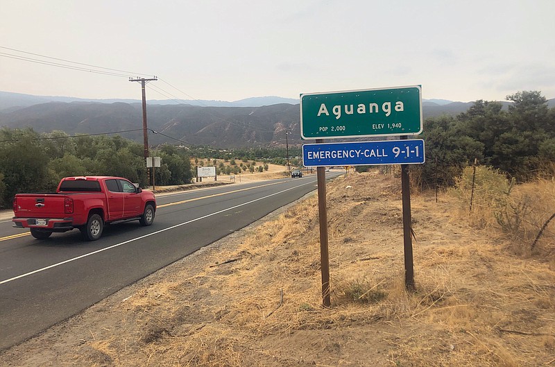 Traffic passes along State Route 371 entering the town of Aguanga, in Riverside County, Calif. on Tuesday, Sept. 8, 2020. Seven people were found fatally shot at an illegal marijuana growing operation in Aguanga. The crime scene was discovered before dawn Monday after deputies responded to a report of an assault with a deadly weapon at a home in the unincorporated community of Aguanga, north of San Diego, the Riverside County Sheriff's Department said in a statement late Monday. (AP Photo/Elliot Spagat)