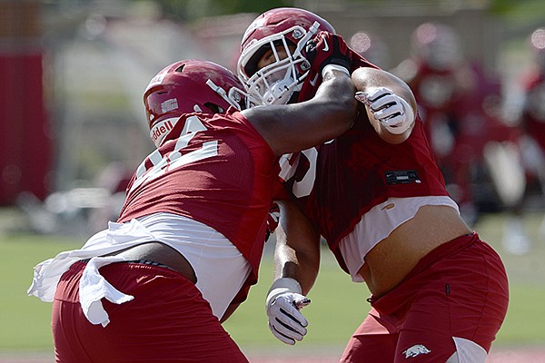 Arkansas defensive linemen Jonathan Marshall (left) and Isaiah Nichols work through a drill Wednesday, Aug. 19, 2020, during practice at the university practice field in Fayetteville.