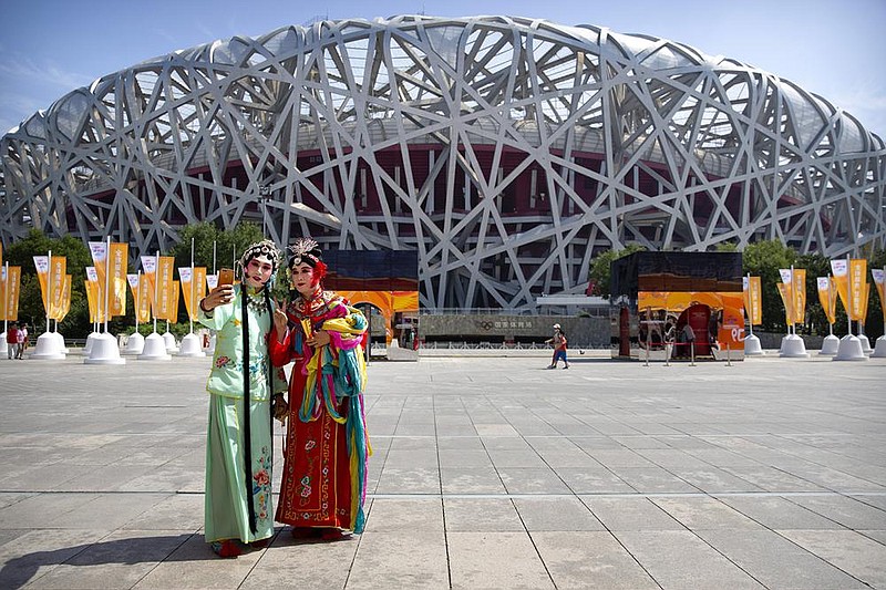 Performers dressed in traditional Chinese opera costumes take a selfie in front of the National Sta- dium, also known as the Bird’s Nest, at the China International Fair for Trade in Services in Beijing on Saturday. (AP/Mark Schiefelbein) 