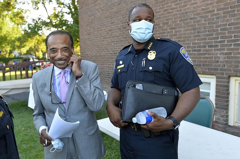 Rochester, N.Y., Police Chief La’ron singletary, shown with the rev. Lewis W. stewart before a community meeting last week, announced his retirement tuesday and said “events over the past week are an attempt to destroy my character and integrity.” (ap/adrian Kraus) 