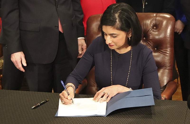 Seema Verma, the head of the Centers for Medicare and Medicaid Services, signs paperwork at the state Capitol in Little Rock, Ark., on Monday, March 5, 2018. Verma was giving the state permission to require that thousands of people on its Medicaid expansion seek ways to work or volunteer.