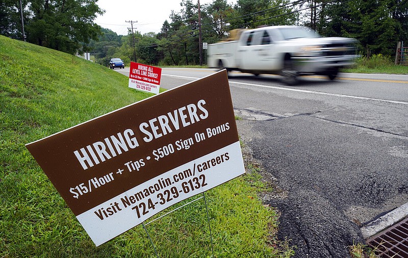 FILE - In this Wednesday, Sept. 2, 2020, file photo help wanted signs for servers and cooks at Nemacolin Woodlands Resort and Spa are displayed along route 40 at the entrance to the resort in Farmington, Pa.