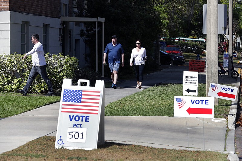 Voters head to a polling station to vote in Florida's primary election in Orlando in this March 17, 2020, file photo. A federal appellate court ruled Friday, Sept. 11, 2020, that Florida felons must pay all fines, restitution and legal fees before they can regain their right to vote, reversing a lower court judge's decision.